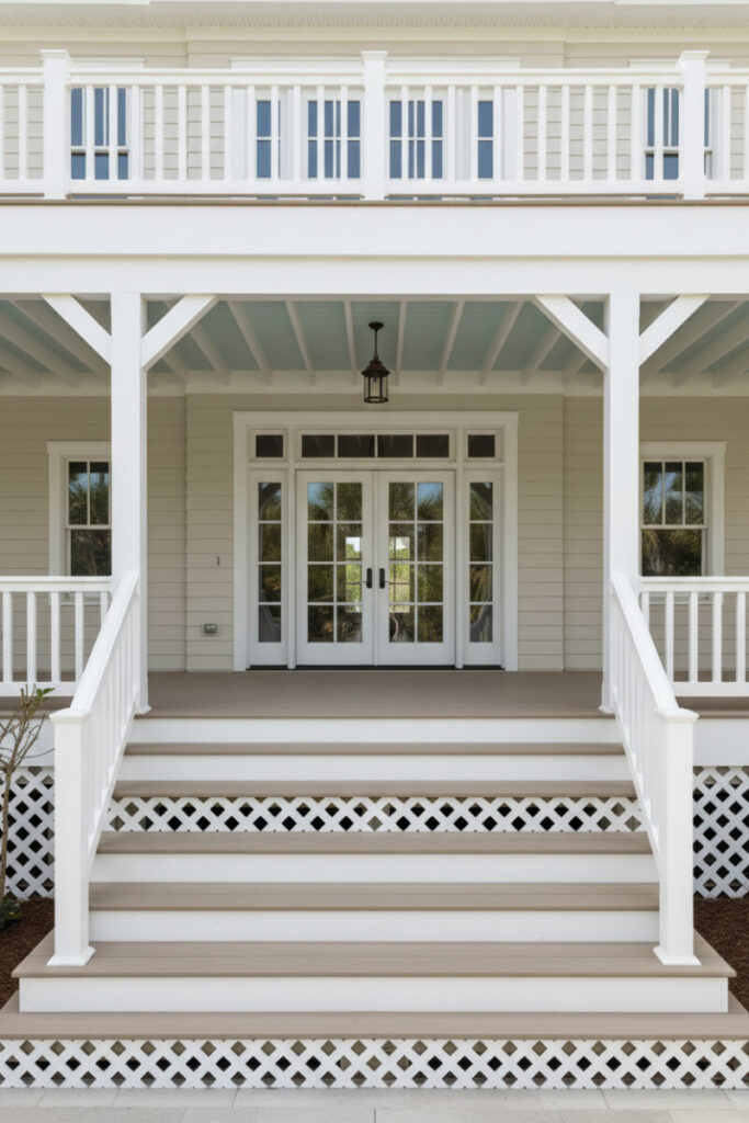 Symmetrical porch showcasing white diamond lattice on skirt and stair risers, taupe treads, and French doors—timeless accent for backyard deck design.