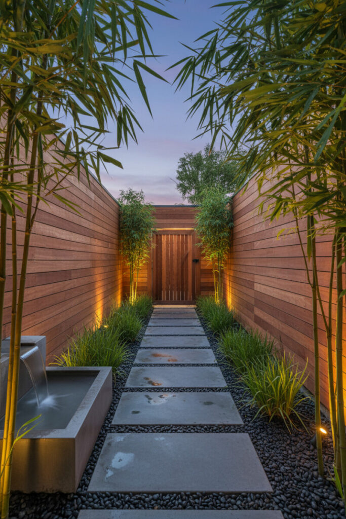 Zen corridor with rectangular concrete basin fountain, slate pavers over dark basalt stones, and redwood fences—low maintenance side yard landscaping.